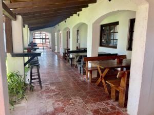 a hallway with tables and chairs in a building at cuatro lunas hotel in Punta Del Diablo