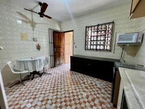 Una cocina con una mesa y una ventana y un suelo. en Refugio das Estações Iguaba Grande, en Iguaba Grande