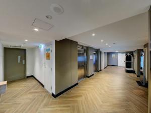 an empty hallway in an office building with wooden floors at ibis budget Sydney Airport in Sydney