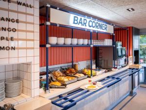 una cucina con un bancone da bar con piatti e cibo di ibis budget Le Cannet des Maures a Le Cannet-des-Maures