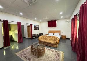 a bedroom with a bed and a couch and a chair at Skyline Rooftop Studio in Muzaffarabad