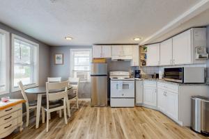 a kitchen with white cabinets and a table with chairs at Nancy's Villa in Hampton +11 photos