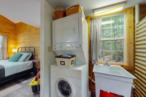 a bathroom with a washing machine and a sink at Lazy Lumberjack Lakeside Cottage in Franklin