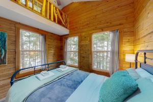 a bedroom with a bed in a log cabin at Lazy Lumberjack Lakeside Cottage in Franklin