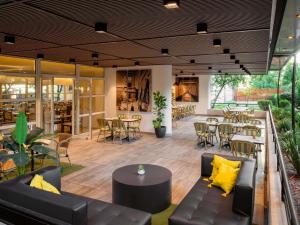 a restaurant with couches and tables and chairs at Novotel Santiago Vitacura in Santiago