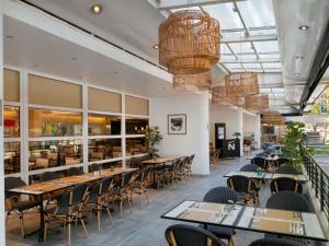 a dining room with tables and chairs and windows at Novotel Santiago Vitacura in Santiago