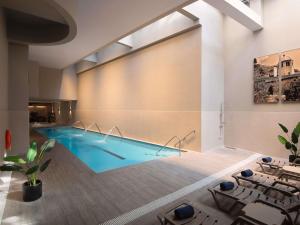 a large swimming pool in a room with a pool at Novotel Santiago Vitacura in Santiago +239 photos