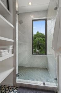 a bathroom with a glass shower with a window at Heated Pool Luxury Zilker home Sleeps 8 great view in Austin