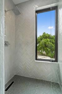 a bathroom with a shower with a window at Heated Pool Luxury Zilker home Sleeps 8 great view in Austin