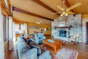 a living room with a couch and a stone fireplace at Morris Villa Upper in Lake Junaluska