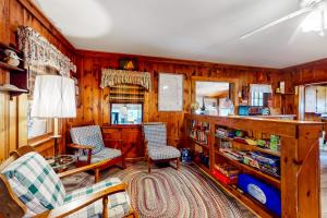 a living room with two chairs and a book shelf at Big Cottage in Flaggs Trailer Park +18 photos