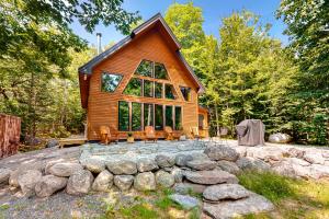 a log cabin in the woods with a stone wall at Lazy Lumberjack Hilltop Cabin in Franklin