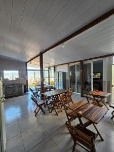 a patio with wooden tables and chairs and a kitchen at MEG House Hostel in Florianópolis