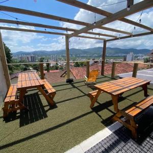 a patio with two picnic tables and a pergola at MEG House Hostel in Florianópolis +47 photos