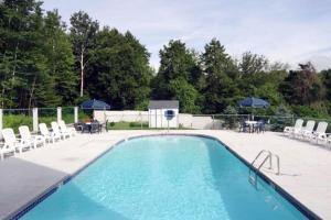 a swimming pool with chairs and a table and umbrellas at Seafarer Resort-Unit 107 in Ogunquit