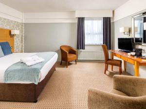 ボルトンにあるMercure Bolton Georgian House Hotelのベッドと机があるホテルの部屋