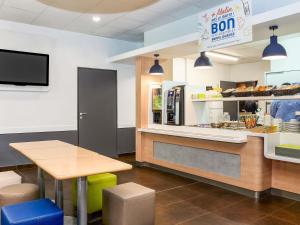 a fast food restaurant with a table and a counter at Ibis Budget Lille Gares Vieux-Lille in Lille