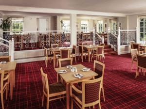ボルトンにあるMercure Bolton Georgian House Hotelの木製のテーブルと椅子のあるダイニングルーム