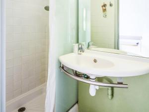 a bathroom with a sink and a mirror at Ibis budget Périgueux in Périgueux +29 photos