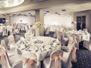 ボルトンにあるMercure Bolton Georgian House Hotelの白いテーブルと椅子が置かれた宴会場