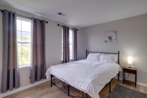 a bedroom with a bed with white sheets and a window at Family Home Near UMD and Dtwn Silver Spring! in Adelphi