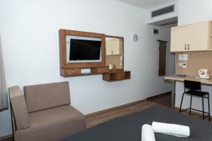 Una sala de estar con un sofá y un televisor en una pared. en Boró Apartman, en Tiszafüred