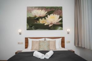 Un dormitorio con una cama con una pintura encima. en Boró Apartman, en Tiszafüred