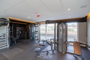 a gym with treadmills and machines in a building at Studio completo a poucos passos da Praia - KPL0806 in São José