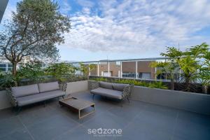 a patio with two couches and a table on a building at Studio completo a poucos passos da Praia - KPL0806 in São José