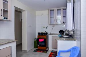 a small kitchen with white cabinets and an oven at Jacky's Fully Furnished Apartment milimani suites in Nakuru