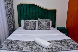 a bed with a towel laying on top of it at Jacky's Fully Furnished Apartment milimani suites in Nakuru +11 photos