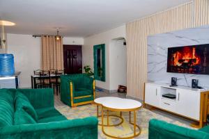 a living room with green furniture and a tv at Jacky's Fully Furnished Apartment milimani suites in Nakuru