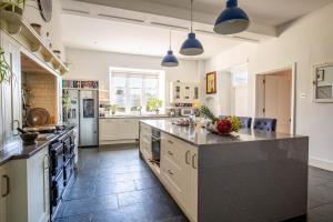 eine große Küche mit einer großen Insel in der Mitte in der Unterkunft Luxury Manor House in the Oxfordshire Cotswolds in Garforth + 77 Fotos