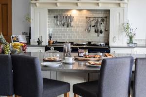 eine Küche mit einem Tisch mit Tellern voller Essen darauf in der Unterkunft Luxury Manor House in the Oxfordshire Cotswolds in Garforth