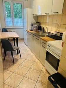 a kitchen with white cabinets and a table and a sink at Włocławek Norwida in Włocławek