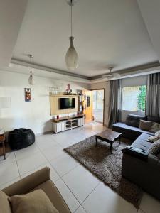 a living room with a couch and a tv at Casa com Carregador para Carro e Quintal Pet, WiFi 500 in Jundiaí
