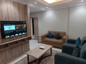 un soggiorno con divani e TV a schermo piatto di امواج الحمراء للشقق المخدومة2 a Gedda