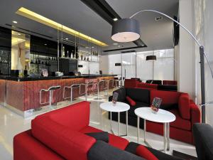 a living room with red couches and a bar at Ibis Bangkok Sukhumvit 4 in Bangkok +24 photos