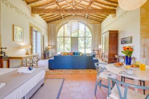 ein Wohnzimmer mit einem Bett und einer blauen Couch in der Unterkunft Les Abeilles, 100 m2 Loft, Nature and Light in Vérac