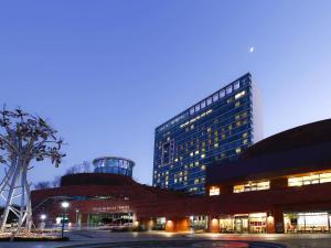 ein großes Gebäude vor einem Gebäude in der Unterkunft Grand Mercure Ambassador Changwon in Changwon