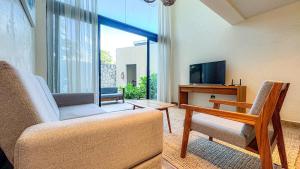un salon avec un canapé et une télévision dans l'établissement Nook Tulum Luxury Condohotel by Marea, à Tulum