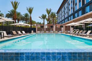 a swimming pool at a hotel with chairs and a building at Element by Marriott Las Vegas Symphony Park in Las Vegas