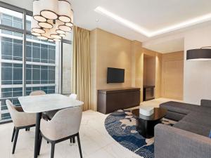 a living room with a table and a couch at Novotel Dubai Gold District in Dubai