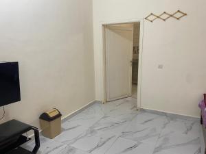 an empty room with a white wall and a door at هوستل خدمه مبيت in Disah +4 photos