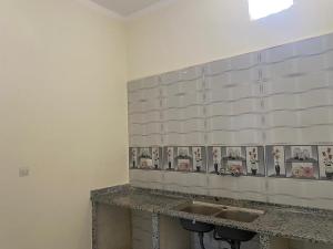 a bathroom with two sinks and pictures on the wall at هوستل خدمه مبيت in Disah