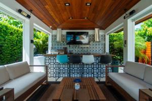 een afgeschermde veranda met twee banken en een bar bij Greenview Villa/Luxury Heated Pool Home Golf View in Kendale Lakes