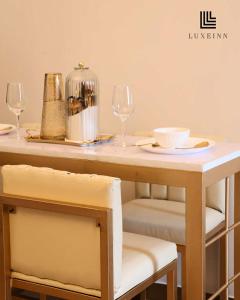 - une table avec deux chaises et une table avec des verres à vin dans l'établissement LuxeInn, à Trece Martires 3 autres photos