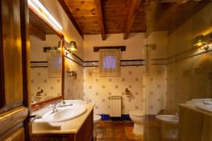 Un baño con dos lavabos, un inodoro y un espejo. en Hospedium Hostería Rural Isabel La Católica, en Aranda de Duero 39 fotos más