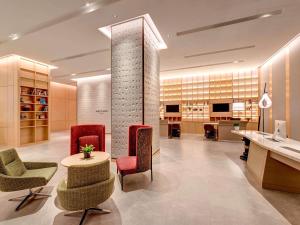 a lobby with chairs and a table and a counter at Mercure Kuala Lumpur Glenmarie in Shah Alam