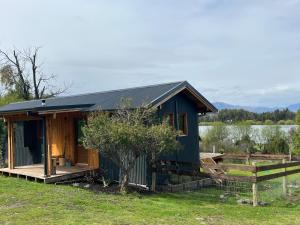 a small cabin with a porch and a fence at El Bosque in Trevelín